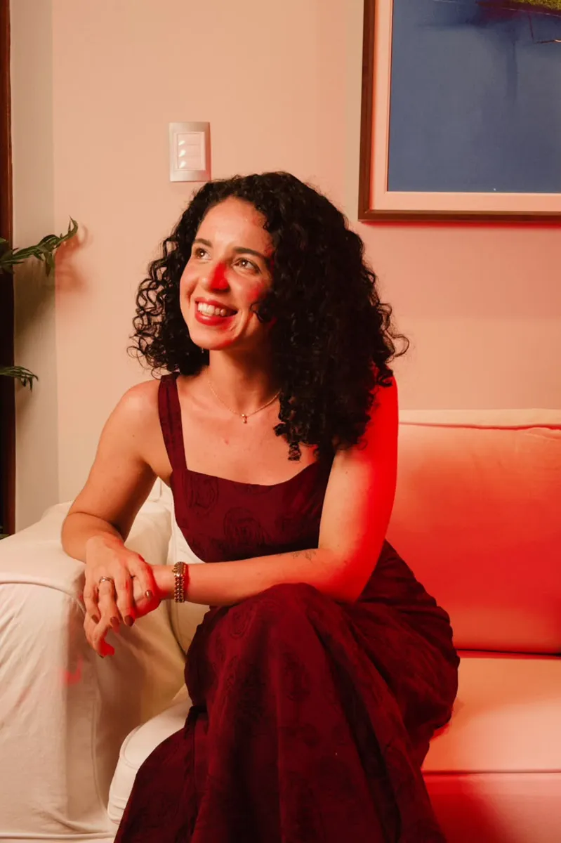 Millena Barreto sorrindo, sentada em um sofá