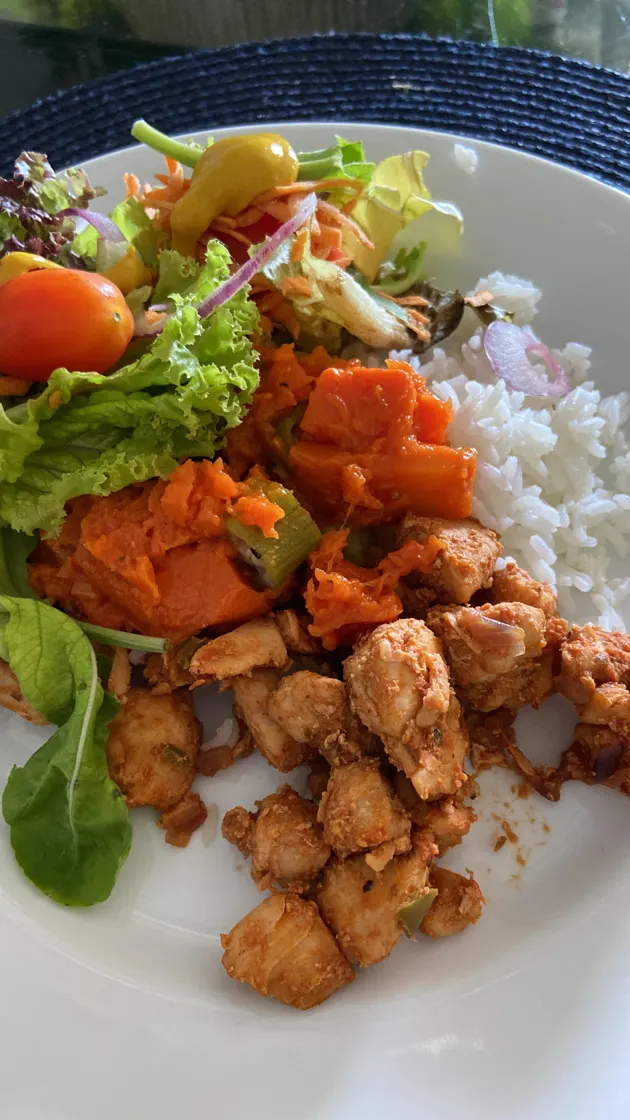 Prato com frango em cubos, abóbora, arroz e salada