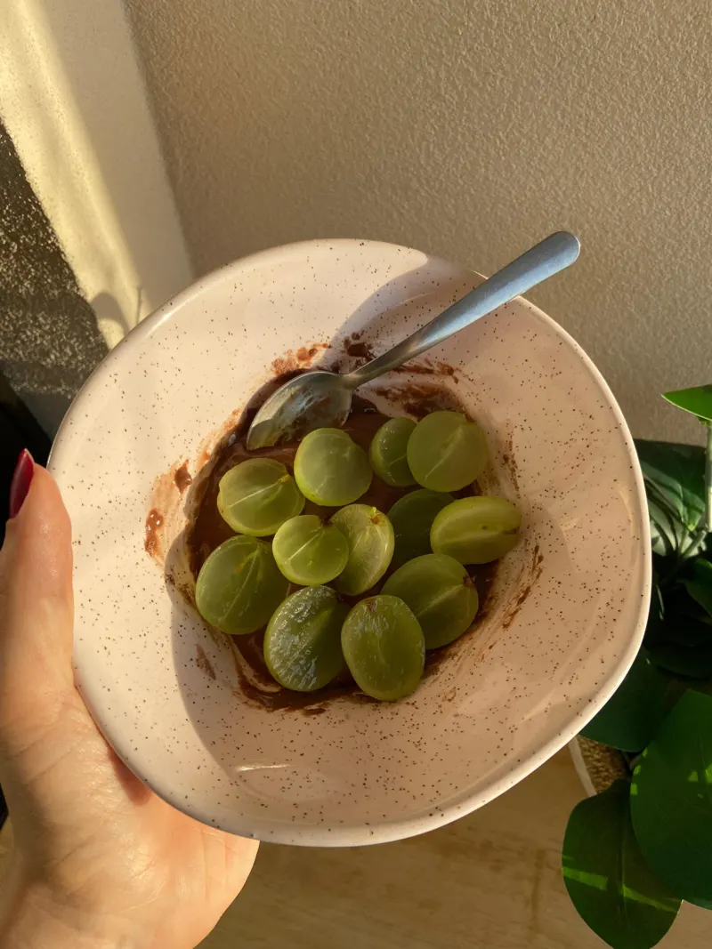 Tigela com creme de chocolate e uvas verdes